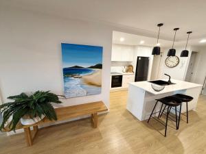 a kitchen with a painting of the beach at Jubilee Apartment 05 - Bring your own linen in South West Rocks
