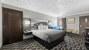 a hotel room with a bed and a desk at Super 8 by Wyndham Norman West OK in Norman +7 photos