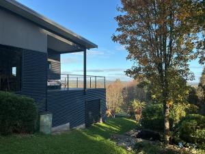 a deck on the side of a house with a tree at Black Hill Retreat, Ballarat in Nerrina