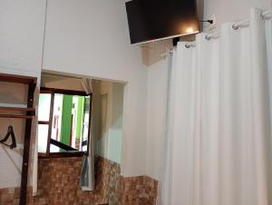 a room with a white curtain and a window at Pousada Campo Alegre Eireli in Itatiaia