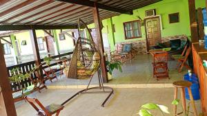 a porch with chairs and a hanging swing at Pousada Campo Alegre Eireli in Itatiaia