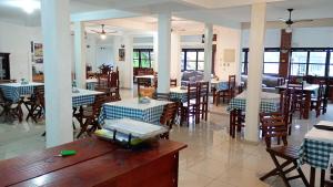 a dining room with tables and chairs and tablesearcher at Pousada Campo Alegre Eireli in Itatiaia