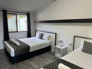 a bedroom with two beds and a window at Allan Cunningham Motel in Toowoomba