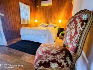 a bedroom with a bed and a chair at Reina Mar Jacuzzi Exclusivo in Barra de Portezuelo
