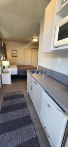 a kitchen with a sink and a bed in a room at Aalton Motel in Christchurch