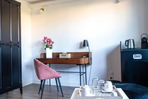 a desk in a room with a pink chair at Suite Touraco, clim, balneo, terrasse - Parc des Oiseaux in Villars-les-Dombes