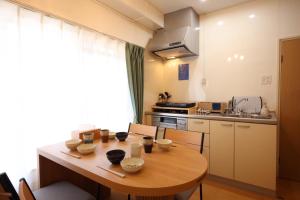 a kitchen with a wooden table with chairs and a dining room at New コスパ重視セール開催中!久留米駅徒歩5分コンビニ1分!ファミリー 友人快適!キッズエリア大好評 in Kurume