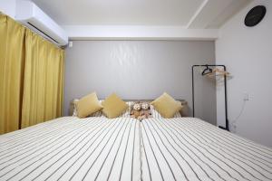 a bedroom with a large white bed with yellow pillows at New コスパ重視セール開催中!久留米駅徒歩5分コンビニ1分!ファミリー 友人快適!キッズエリア大好評 in Kurume +60 photos