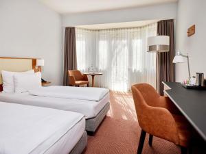 ein Hotelzimmer mit zwei Betten und einem Schreibtisch in der Unterkunft Mercure Hotel Düsseldorf City Center in Düsseldorf + 93 Fotos