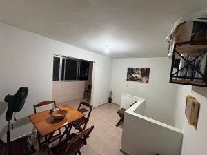 a kitchen and dining room with a table and chairs at Triplex no litoral in Matinhos