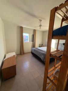 a bedroom with a bed and a bunk bed with a ladder at Triplex no litoral in Matinhos