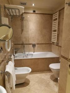 ein Badezimmer mit einer Badewanne, einem WC und einem Waschbecken in der Unterkunft Suites Torre Dell'Orologio in Venedig