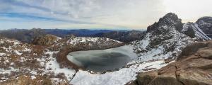 a large crater in the snow on top of a mountain at Cabaña Laguna Huemul in Pinto