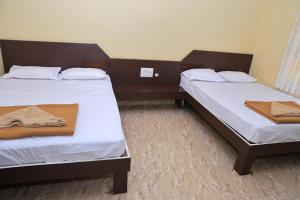 two beds in a hotel room with towels on them at Horanadu Sanman residency in Kalasa +1 photo
