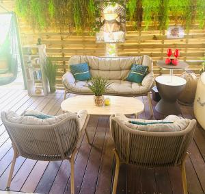 a patio with a couch and chairs and a table at Escale verdoyante in Petit-Bourg +1 photo