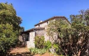 an old stone house with bushes and trees at Stones House in Labeaume