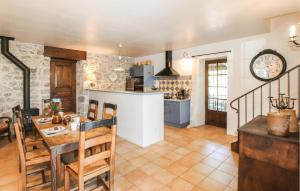 a kitchen and dining room with a table and a clock at Stones House in Labeaume