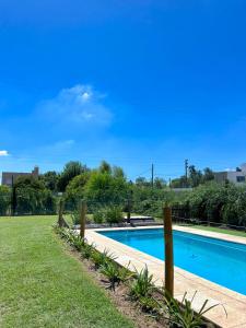a swimming pool in a yard with grass and trees at Las moras quinta in San Nicolás de los Arroyos