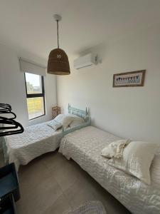 a bedroom with two beds and a pendant light at Las moras quinta in San Nicolás de los Arroyos +14 photos