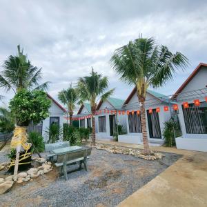 a building with palm trees in front of it at Home An Linh in Thôn Mỹ Nghĩa