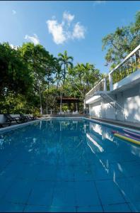 a swimming pool with blue water in front of a building at Las cabañas in Jacó