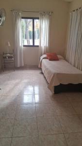 a bedroom with a bed and a large window at El Chaparral Villa Dolores Traslasierra 2 in Piedra Pintada