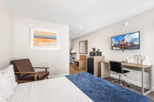 a hotel room with a bed and a desk and chair at Hotel 414 Anaheim in Anaheim