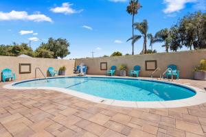 a swimming pool with blue chairs around it at Hotel 414 Anaheim in Anaheim