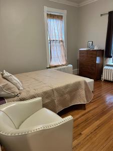 a bedroom with a bed and a chair and a dresser at Robinsdale on broadway in Minneapolis
