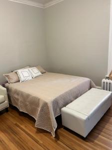 a bedroom with a bed with a ottoman next to it at Robinsdale on broadway in Minneapolis