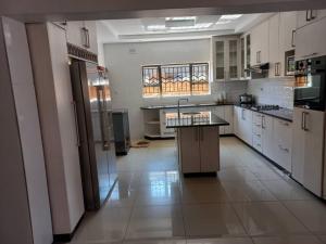 a large kitchen with white cabinets and a large island at Victoria Falls Accomodation in Victoria Falls