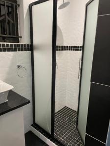a shower with a glass door in a bathroom at Victoria Falls Accomodation in Victoria Falls