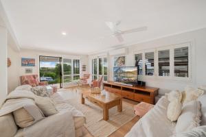 a living room with a couch and a table at 15 Derby Road Moffat Beach in Caloundra