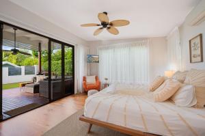 a bedroom with a large bed with a ceiling fan at 15 Derby Road Moffat Beach in Caloundra +14 photos