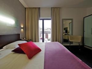 a bedroom with a large bed with a red pillow on it at Mercure Palermo Centro in Palermo +136 photos