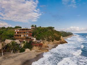 a hotel on a cliff next to the ocean at Jaguar Beachfront Ecohotel & Spa in Santa Marta