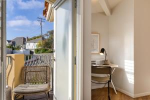 a room with a balcony with a chair and a desk at The Mara Laguna Beach, an AvantStay Hotel in Laguna Beach