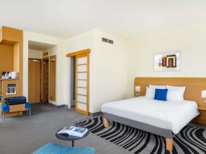 a bedroom with a large bed and a table at Novotel Budapest Danube in Budapest
