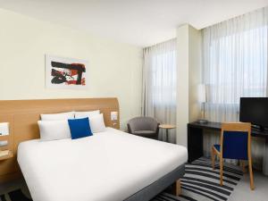 a hotel room with a large bed and a desk at Novotel Budapest Danube in Budapest +96 photos