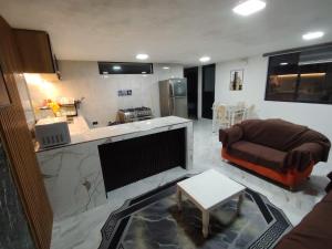a living room with a couch and a kitchen at Departamento Confortable in Latacunga