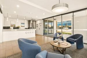 an office lobby with blue chairs and a coffee table at Quest Scarborough in Perth