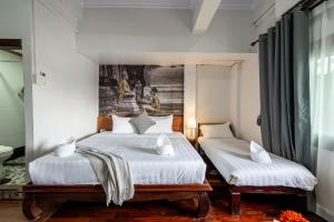 a bedroom with two beds and a painting on the wall at BlueHome Vientiane in Vientiane