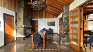 a dining room with a table and chairs and a fireplace at Residencial Astorga in Rancagua