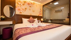 a bedroom with a bed with two swans on it at Lavender SaPa Hotel & Spa Right in the center of Sa Pa - Free foot soak service in Lao Cai
