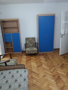 a living room with a chair and a blue door at Apartament in Fălticeni
