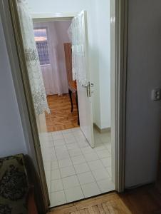 an open door to a room with a tile floor at Apartament in Fălticeni