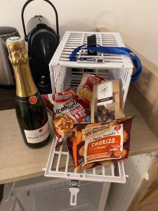 a refrigerator with food and a bottle of champagne at Suite Aracari, clim, balneo, terrasse - Parc des Oiseaux in Villars-les-Dombes