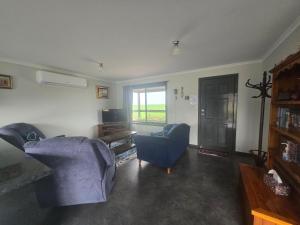 a living room with two chairs and a blue couch at Wudinna Farm View in Wudinna