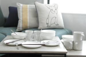 a coffee table with bowls and plates and a cat pillow at Casa Stella 10 by Liaison カーサステラ10 by リエゾン in Osaka