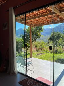 a room with a view of the mountains through a glass door at Casa Jatobá in Ibicoara +26 photos
